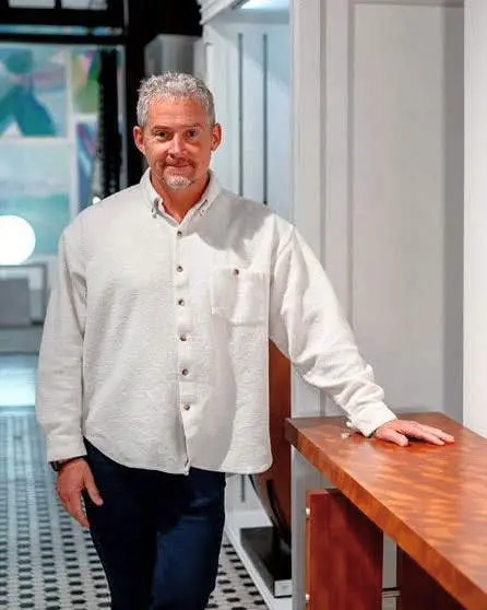 Furniture artisan David Langley standing beside one of his handcrafted cabinets